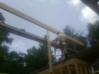 Carpenter setting a ridge beam over a new addition frame — Ice Dam Removal by Roofing Brothers in Wakefield